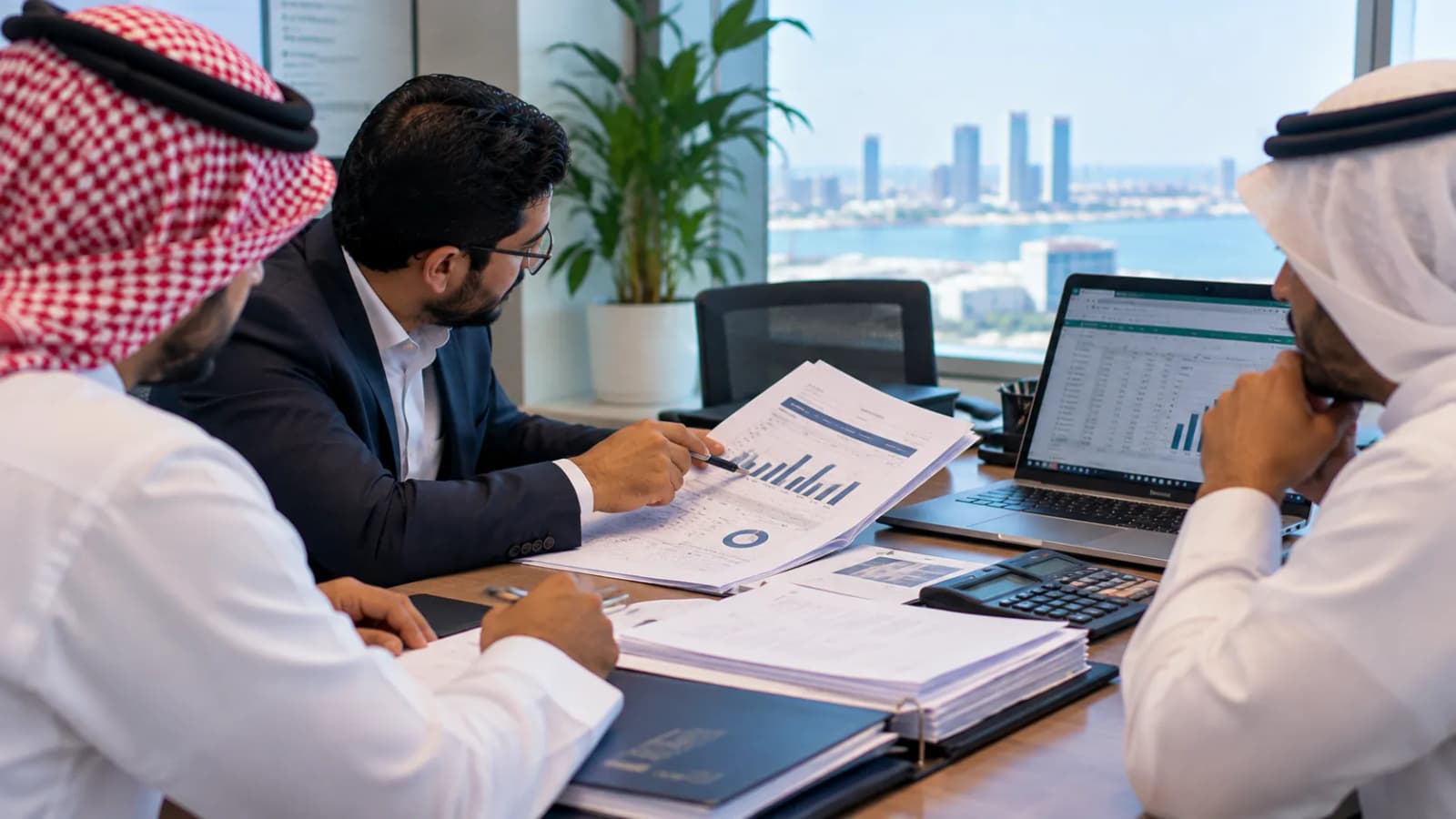 A consultant pointing out figures in a printed financial report to two clients at a meeting table