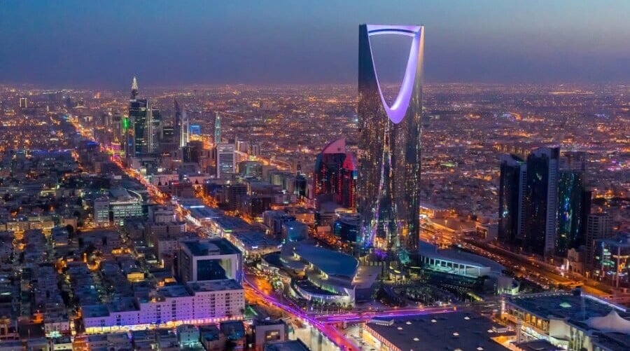 Aerial night view of Riyadh with the Kingdom Centre tower lit above the city skyline